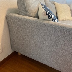 グレーのモダンソファとクッション2個の画像