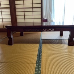 ダークブラウンの木製テーブル彫刻入りの画像