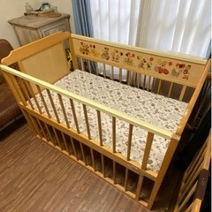 レトロなミッキーの柄がおしゃれな木製のベビーベッドの画像