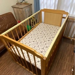レトロなミッキーの柄がおしゃれな木製のベビーベッドの画像