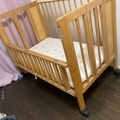 キャスター付き木製ベビーベッドの画像