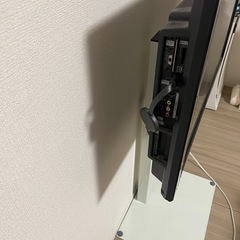 スタンド付きテレビ、2人用ダイニングテーブルの画像