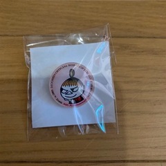 ムーミンキャラクターのイラストが施されたラベンダー色のがま口ポーチ＋バッチの画像