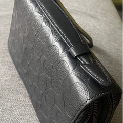 COACHのブラックレザー製クラッチバッグ、カードポケット付きで実用的。の画像