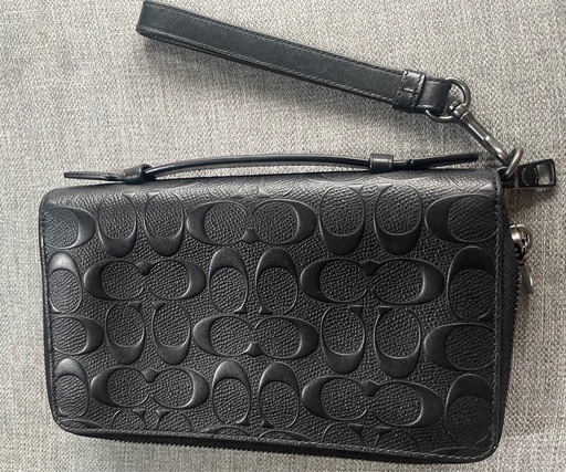 COACHのブラックレザー製クラッチバッグ、カードポケット付きで実用的。