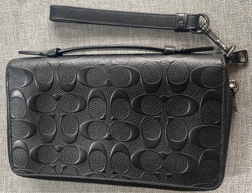 COACHのブラックレザー製クラッチバッグ、カードポケット付きで実用的。