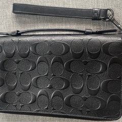 COACHのブラックレザー製クラッチバッグ、カードポケット付きで実用的。の画像