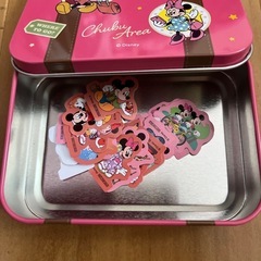 ミッキーとミニーの缶ケースと付属のミニステッカーの画像
