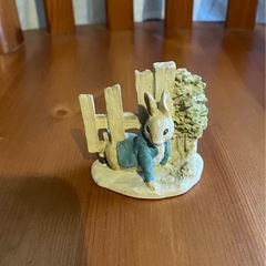 柵をくぐるピーターラビット小さな置物の画像