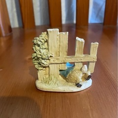 柵をくぐるピーターラビット小さな置物の画像