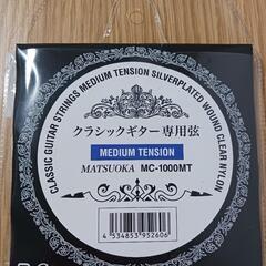 新品のクラシックギターのチューニングペグと弦の画像