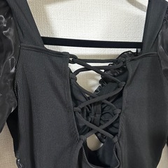 フリルとレースアップデザインの黒いワンピースの画像