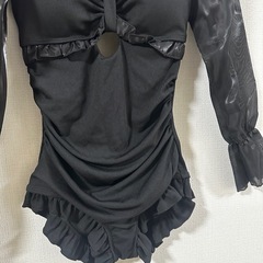 フリルとレースアップデザインの黒いワンピースの画像
