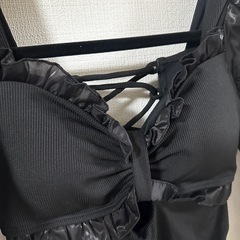 フリルとレースアップデザインの黒いワンピースの画像