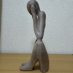 淡いベージュの石材で作られた抽象的な人型の彫刻。  - 素材: 石材 - デザイン: 抽象的な人型 - 色: 淡いベージュ - 高さ: 約30cm - 用途: インテリア装飾  ご覧いただきありがとうございます。  骨董品屋で購入して部屋に飾っていました。 耳を塞いでいますが、胸がハートになっているところが気に入りました。 整理のために出品します。  よろしくお願いいたします。の画像