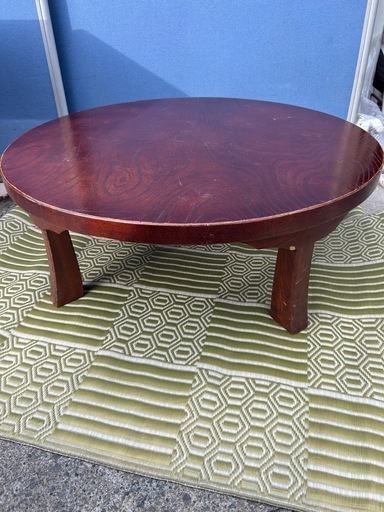 円形の木製座卓、折りたたみ可能でダークブラウンの仕上げ。