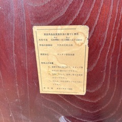 円形の木製座卓、折りたたみ可能でダークブラウンの仕上げ。の画像