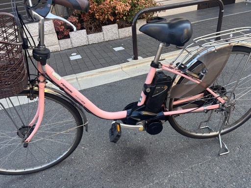 Panasonicピンクのシティタイプ電動アシスト自転車、前カゴ付きで便利。