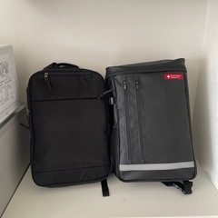 災害用バッグ2個と木製棚の画像