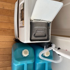 石油ファンヒーターと石油のボトル２つの画像