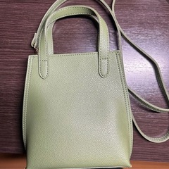 女性の手のひらサイズのコンパクトなシンプルバックの画像