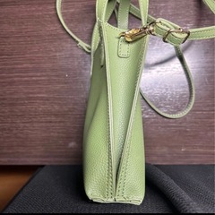 女性の手のひらサイズのコンパクトなシンプルバックの画像