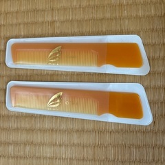 オレンジ色のプラスチック製コーム2本。（くし）の画像