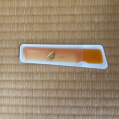 オレンジ色のプラスチック製コーム1本。（くし）の画像