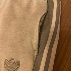 グレーのadidasジョガーパンツ、サイドジッパーポケットの画像