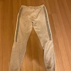 グレーのadidasジョガーパンツ、サイドジッパーポケットの画像