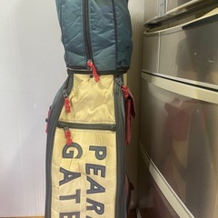 青・赤・クリームの配色が特徴のPEARLY GATESキャディバッグ。の画像