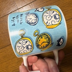 時計と猫柄のマグカップの画像