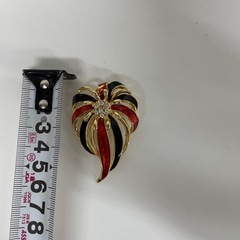 赤と黒のモチーフブローチの画像