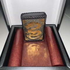 新品の金色ドラゴン模様ライター カバーと中古の本体のセットの画像