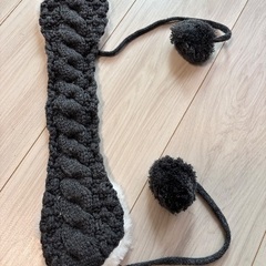 ポンポン付きの黒系ニット帽と耳当ての画像