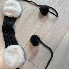 ポンポン付きの黒系ニット帽と耳当ての画像