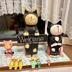 大きな瞳と丸みのある姿が可愛い木製のネコの置物(バリ島で購入)とぬいぐるみの画像
