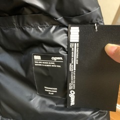 未使用フード付きの軽量グレーのロングダウンジャケット、前面ポケット付き。の画像