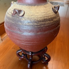陶器大きい壺と木製飾り台の画像