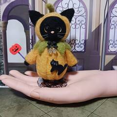 ハロウィン　かぼちゃのコスチュームの黒猫　　スタンド付きの画像