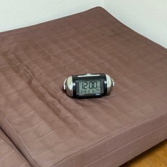 目覚ましと折りたたみベットの画像