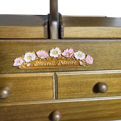 木製の花柄装飾が施されたコンパクトな収納ボックスの画像