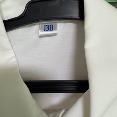 シンプルなホワイトの長袖シャツ、130サイズ、胸ポケット付きの画像