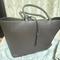 グレーのVORQITトートバッグ、内側にポケットとファスナー付き。の画像