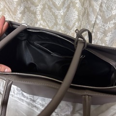 グレーのVORQITトートバッグ、内側にポケットとファスナー付き。の画像