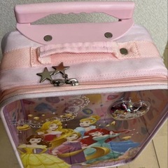 ディズニープリンセスデザインの可愛いキャリーケースです♪ 旅行やお出かけの時にお子さまが荷物を自分で運べます！ ディズニーランドやシーに行く時に持って行っても可愛いですね！  デザイン: プリンセスキャラクターのイラスト ハンドル: ピンクの持ち手付き サイズ: 縦40㎝　横25㎝　奥行15㎝ 装飾: キラキラのハート型チャーム付き の画像