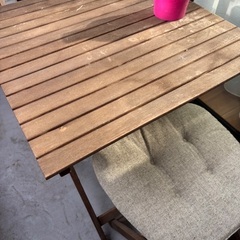 木製テーブルと折りたたみ椅子セットの画像