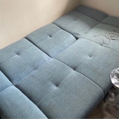 ワイヤレスイヤフォンとソファーベッドの画像