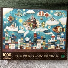 1000ピース ジグソーパズル イラスト/アート 西村典子 空想街カフェの奥の空飛ぶ魚の街 （50×75cm） 12-620sの画像
