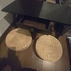 麦わらクッション2つと小さなテーブルの画像